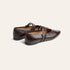A pair of dark brown leather Mary Jane flats with double straps and gold-tone buckle details, shown on a light cream background.