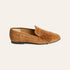 A single tan suede loafer with a fringed tassel detail across the vamp, shown in a side profile on a light cream background.