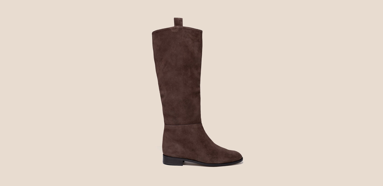 Brown suede knee-high boot on a beige background